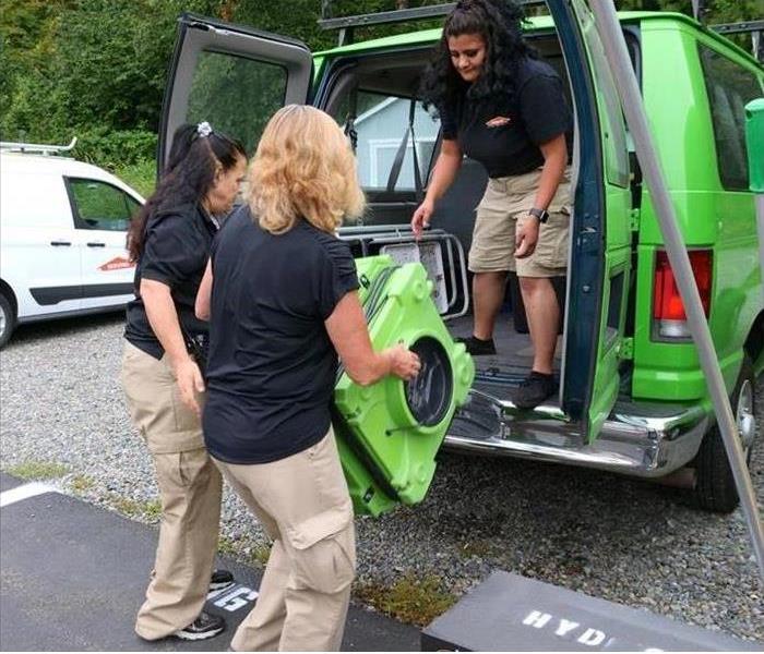 SERVPRO technicians loading a vehicle with drying equipment